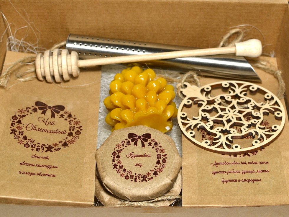 Состав: травяной чай, мед, ёлочная игрушка, свеча из пчелиного воска, баночка мёда 125г., ложка для мёда, тубус-заварник для чая.